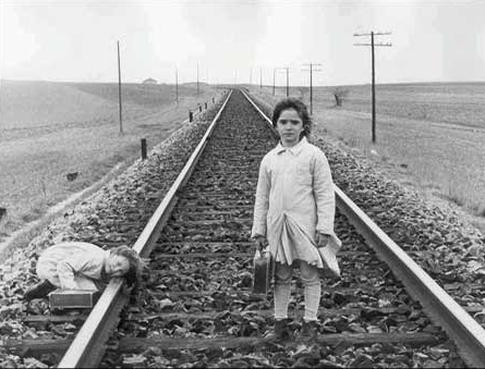 영화 '벌집의 정령' 한 장면. 철로 위의 두 소녀. 철로는 이동과 변화를 암시하는 상징적 공간으로, 억압된 환경 속에서도 자유와 상상력을 향한 순례의 길을 암시한다. 이 장면에 이어지는 기차의 질주는 카메라를 로우앵글로 해 위압감을 배가한다.