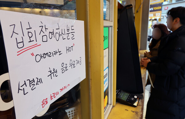 국회에서 윤석열 대통령에 대한 탄핵소추안 재표결이 이뤄지는 14일 오후 부산 부산진구 서면의 한 카페에서 선결제 관련 안내문이 놓여 있다. 2024.12.14. 연합뉴스