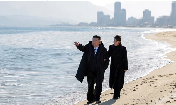 북한 동부해안 도시 원산 앞바다 해변을 걷고 있는 김정은 국무위원장과 그의 딸 김주애. 뒤에 북이 대대적으로 선전해 온 원산 리조트 단지의 건물들이 보인다.  조선통신사 로이터 가디언 2월 20일