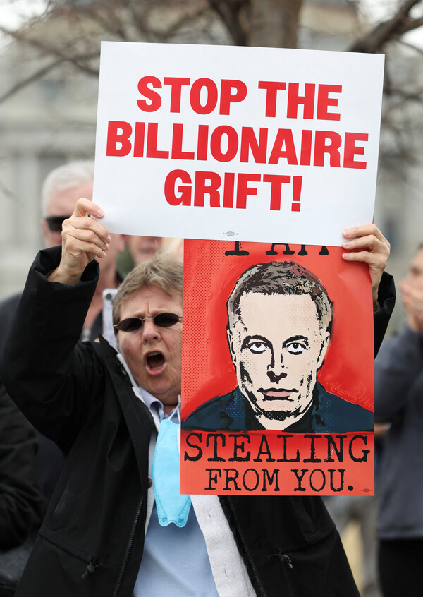 25일, 도널드 트럼프 미국 대통령과 정부효율화서비스부 수장이자 갑부인 일론 머스크에 항의하는 시위자가 미국 의사당 밖에서 머스크를 묘사한 플래카드를 들고 있다. 2025.2.25. 로이터 연합뉴스