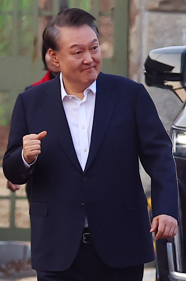 석방된 윤석열 대통령이 8일 경기도 의왕시 서울구치소 앞에서 경호차량에서 내려 지지자들에게 인사하며 주먹을 불끈 쥐어보이고 있다. 2025.3.8. 연합뉴스