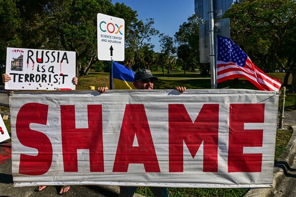 3월 14일 미국 플로리다주 웨스트 팜 비치에 있는 도널드 트럼프 미국 대통령의 마라라고 리조트 근처에서 열린 "우크라이나는 절대 항복하지 않을 것" 시위에 참석한 사람들이 "수치(부끄러움)" 배너와 "러시아는 테러리스트" 피켓을 들고 있다. 2025.3.14. AFP 연합뉴스