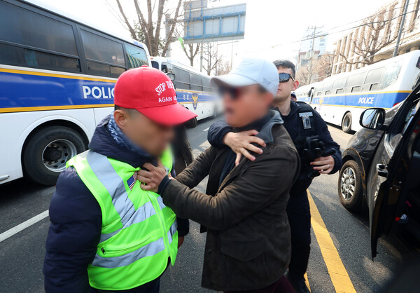 21일 서울 종로구 헌법재판소 앞에서 차량에 장착된 확성기로 대통령 탄핵 촉구 기자회견 참석자들을 향해 지속적으로 욕설을 한 윤석열 대통령 극렬 지지자(오른쪽)에게 한 남성이 항의하자 차에서 내려 강하게 밀치고 있다. 2025.3.21. 연합뉴스