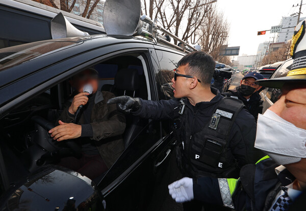 21일 서울 종로구 헌법재판소 앞에서 윤석열 대통령 극렬 지지자가 경찰의 제지에도 불구하고 대통령 탄핵 촉구 기자회견 참석자들을 향해 욕설을 하고 있다. 2025.3.21. 연합뉴스