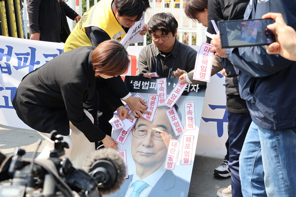 12·3 내란 사태의 장기화를 야기했던 한 대행의 대형 사진에 그를 규탄하는 문구가 적힌 스티커를 붙이는 퍼포먼스가 기자회견 후반부에 진행됐다. ⓒ 임석규