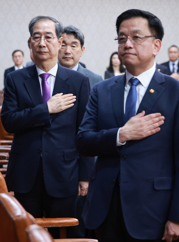 한덕수 대통령 권한대행 국무총리와 최상목 경제부총리 겸 기획재정부 장관이 25일 정부서울청사에서 열린 국무회의에서 국기에 경례를 하고 있다. 2025.3.25. 연합뉴스