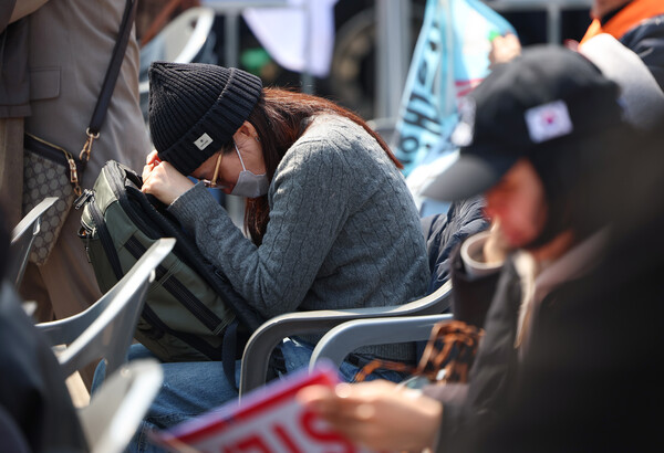 헌재의 윤석열 전 대통령 탄핵 인용이 발표된 4일 서울 용산 대통령실 인근에서 한 지지자가 고개를 숙이고 있다. 2025.4.4 . 연합뉴스