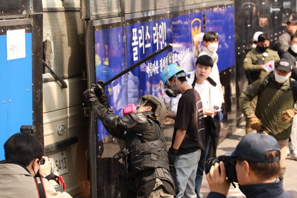 4일 서울 종로구 헌법재판소 인근에서 윤석열 대통령 지지 집회 참가자 중 한 명이 헌재의 윤 대통령 파면 결정에 경찰이 세운 가벽 사이로 보이는 차량을 부수고 있다. 2025.4.4.연합뉴스