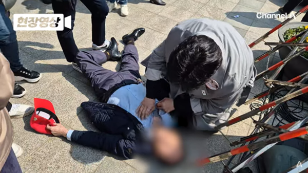 서울 용산구 전쟁기념관 앞에서 윤석열 지지자가 쓰러졌다. 이 지지자는 주변의 부축을 받아 곧 일어났다. 2025.4.4. 채널에이(A) 유튜브 채널 갈무리 화면.