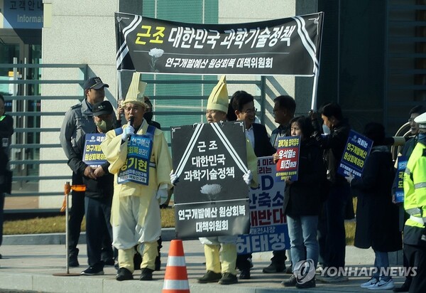 24일 대전 한국전자통신연구원(ETRI)에서 열린 과학기술정보방송통신위원회 국정감사 시작 전 전국공공연구노동조합 관계자들이 연구개발(R＆D) 예산 삭감 등에 항의하는 팻말을 들고 있다. 2023.10.24. 연합뉴스