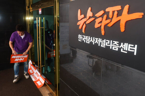 뉴스타파 직원들이 14일 오전 대장동 허위 보도 의혹으로 압수수색 중인 서울 중구 뉴스타파 출입문 앞에 팻말을 붙이고 있다. 2023.9.14. 연합뉴스