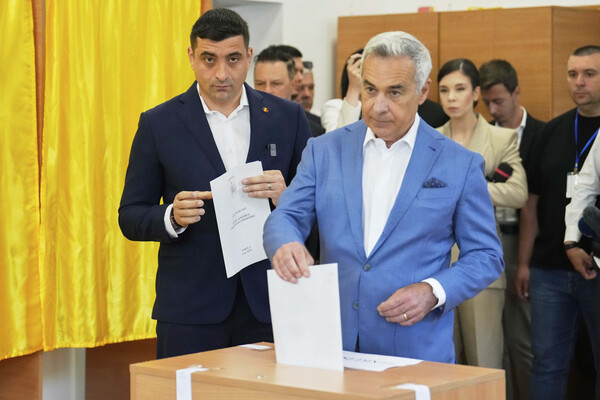 루마니아 헌법재판소의 작년 11월 대선 1차투표 무효 결정과 중앙선관위의 출마 불허 조치로 대선에 재출마하지 못한 무소속의 컬린 제오르제스쿠 후보가 4일 제오르제 시미온 후보(왼쪽)와 함께 모고소아니아 선거구에서 투표하고 있다. 2025.5.4. AP 연합뉴스 