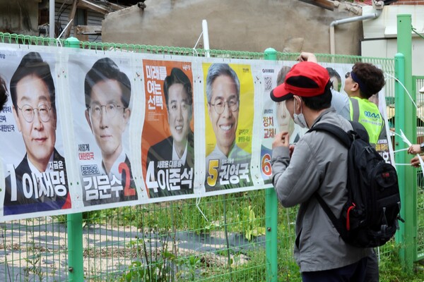 제21대 대통령 공식 선거운동이 계속되고 있는 가운데 15일 광주 동구 운림동 한 골목에서 시민이 부착된 대통령 선거 벽보를 바라보고 있다. 2025.5.15. 연합뉴스