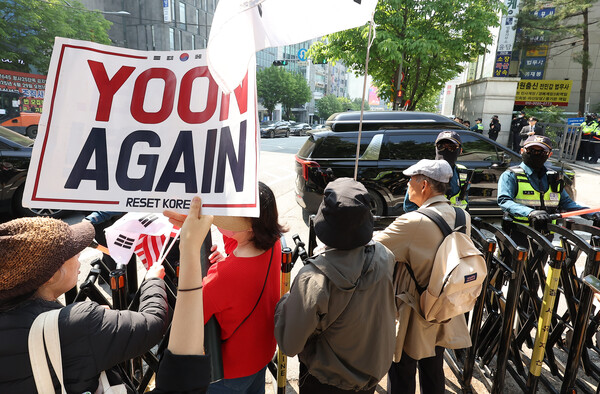 윤석열 전 대통령의 내란 우두머리 혐의 형사재판 3차 공판을 앞둔 12일 서울 서초구 서울중앙지방법원 윤 전 대통령이 탄 차량 행렬이 지나가자 지지자들이 손팻말을 흔들고 있다. 2025.5.12. 연합뉴스