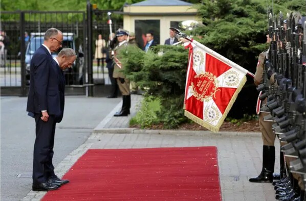 프리드리히 메르츠 독일총리(맨왼쪽)가 취임식 다음날인 지난 5월 7일 처음으로 폴란드를 공식방문하면서 수도 바르샤바에서 도날트 투스크 폴란드 총리(오른쪽 고개숙인 사람)와 함께 의전행사에 임하고있다.  마이니치신문 5월 28일