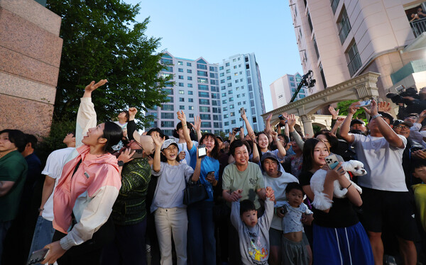 제21대 대통령 선거일인 3일 오후 더불어민주당 이재명 후보의 자택인 인천 계양구 아파트에서 주민들이 핸드폰으로 방송사 출구조사 결과를 보며 환호하고 있다. 2025.6.3 연합뉴스