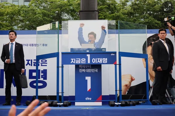 암살 시도와 끊임없는 살해 위협으로 방탄유리의 보호를 받아야 하는 이재명 후보 유세현장 모습.  로이터 가디언 6월 2일