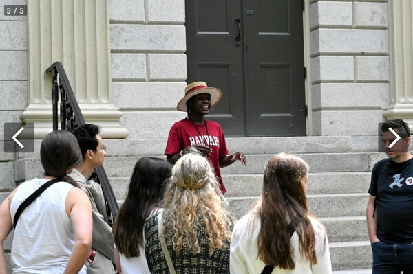 허버드대학을 방문한 관광객들에게 설명해 주는 안내자(모자 쓴 사람).  아사히신문 6월 6일