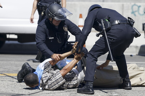 6월 8일 미국 캘리포니아주 로스앤젤레스의 에드워드 R. 로이벌 연방 청사 인근 시위 현장에서 경찰관들이 한 시민을 체포하고 있다. 도널드 트럼프 미국 대통령은 지난 며칠 동안 로스앤젤레스 지역에서 진행된 이민 단속 단속에 반대하는 대규모 시위 이후 캘리포니아주로부터 추가 지원 요청을 받지 않았음에도 불구하고 2,000명의 주 방위군을 배치했다. 2025.6.8  EPA 연합뉴스