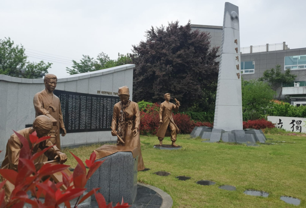 의열체험관 바로 옆 윤세주 생가 터에 세워진 의열기념탑과 3·13 만세운동 군상. 윤세주 집에서 등사기로 독립선언서를 인쇄하고 태극기를 만드는 장면을 형상화했다. (이희용 촬영)