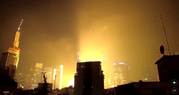 이란의 미사일 공격을 받고 있는 이스라엘 텔아비브. 요격망을 뚫고 도심에 떨어진 미사일이 폭발하면서 밝은 빛과 연기를 내뿜고 있다.   뉴욕타임스 6월 14일 