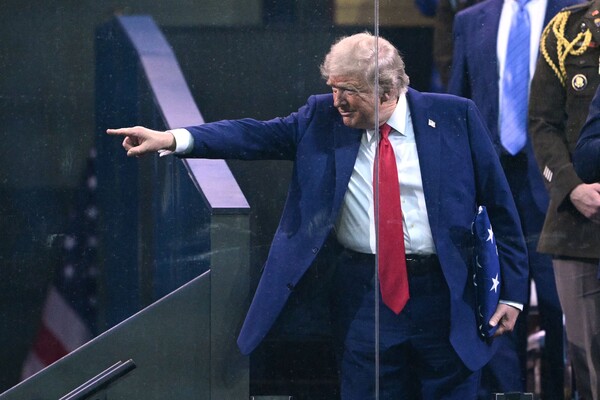 도널드 트럼프 미국 대통령이 6월 14일 워싱턴 D.C.에서 열린 육군 창설 250주년 기념 퍼레이드에서 육군 골든 나이츠(Golden Knights) 대원이 건네준 성조기를 들고 있는 모습. 도널드 트럼프 미국 대통령은 79번째 생일을 맞아 오랫동안 꿈꿔온 군사 퍼레이드를 즐겼고, 전국 곳곳에서 집권 이후 최대 규모의 시위가 벌어지면서 그를 독재자로 몰아붙였다. 2025.6.14. AFP 연합뉴스