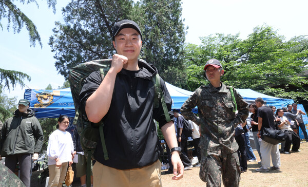 26일 충남 논산시 육군훈련소로 입영하는 한 장병이 병무청의 현역 입영문화제에 참석해 완전군장을 들어보이고 있다.2025.5.26. 연합뉴스