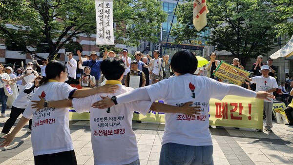 ​'시민언론민들레 사진'조선일보폐간시민실천단'이 23일 오후 서울 세종대로 조선일보 본사 옆 공원에서 개최한 '폐간투쟁 2,000일 기념집회'에서 20대 회원들이 '조선일보 폐간'이라고 쓰인 옷을 입고 춤을 추고 있다. 김성재 사진.