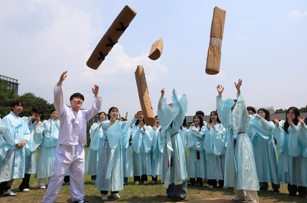 서울 종로구 성균관대학교 금잔디 광장에서 열린 제1회 유생 모꼬지 행사에서 유학대학 학생회 학생들이 대형 윷을 던지며 즐거워하고 있다. 모꼬지란 놀이, 잔치를 뜻하는 토박이말이다. 2025.5.29. 연합뉴스