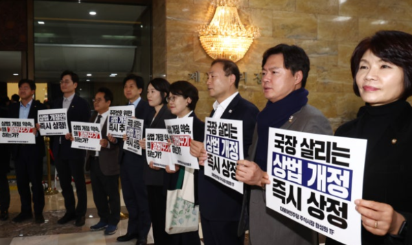 지난 2월 27일 더불어민주당 '주식시장 활성화 TF' 소속 의원들이 서울 여의도 국회 본회의장 앞에서 국민의힘의 상법 개정 이행을 촉구하는 규탄 피켓을 들고 구호를 외치고 있다. 연합뉴스