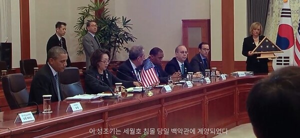 세월호 참사 9일 후 한국을 방문한 오바마 미국 전 대통령이 박근혜 대통령을 만나 세월호 참사 당일 백악관에 게양되었던 성조기를 전달하고 있다. 영화 의 한 장면.  