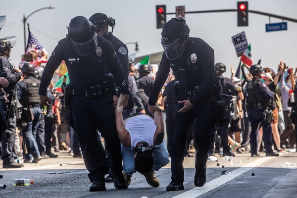미국 로스앤젤레스 경찰(LAPD)이 연방 건물 앞에서 연방 당국의 강압적 불법 이민 단속에 항의하는 한 시위 참석자를 체포해 연행하고 있다. 2025. 06. 08 [AFP=연합뉴스]