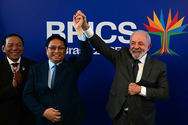 베트남의 팜 민 찐 총리(왼쪽)와 브라질의 루이스 이나시우 룰라 다 시우바 대통령이 7월 5일 브라질 리우데자네이루에서 열린 브릭스 정상회의를 앞두고 양자 회담을 가진 후, 브라질산 소고기의 베트남 첫 수출과 베트남산 틸라피아의 브라질 첫 수출을 축하하며 손을 잡고 있다. 6일부터 리우데자네이루에서 열리는 브릭스 정상회의는 도널드 트럼프 대통령의 강경 무역 정책을 비판할 것으로 예상되지만, 중동을 휩쓸고 있는 위기에 대한 갈등을 해소하는 데 어려움을 겪고 있다. 2025.7.5. AFP 연합뉴스