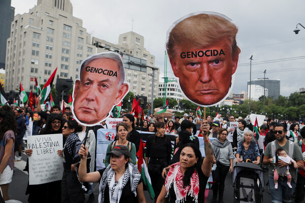 멕시코의 수도 멕시코시티에서 15일 팔레스타인 지지 시위가 진행 중인 가운데 참석자들이 든 베냐민 네타냐후 이스라엘 총리와 도널드 트럼프 미국 대통령의 머리 모형 피킷에 '제노사이드'(집단학살)라고 씌어 있다. 2025. 06. 15 [로이터=연합뉴스]