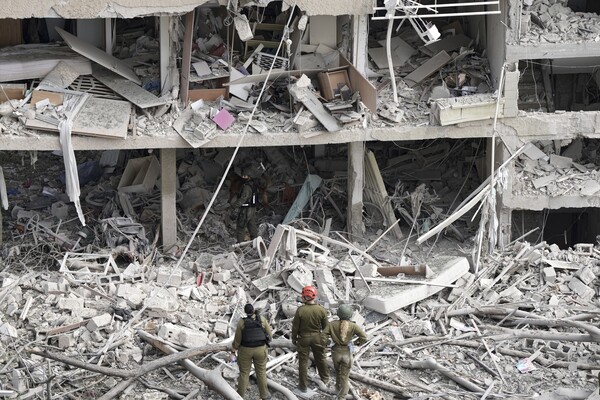 이스라엘 군인들이 이란의 미사일 공격으로 파괴된 텔아비브의 한 건물을 둘러보고 있다. 2025. 6. 22 AP  연합뉴스