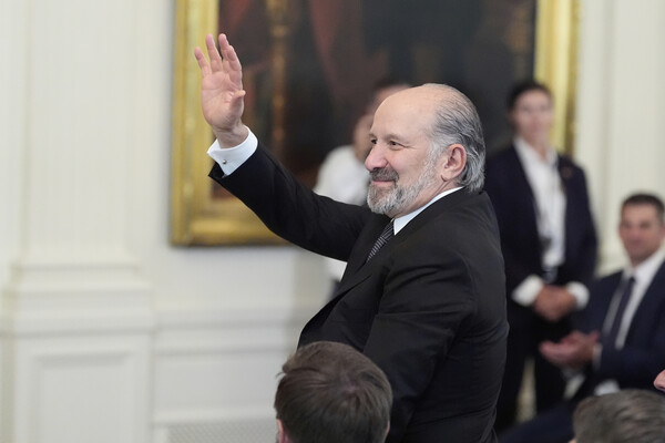 하워드 러트닉 미국 상무장관이 18일 백악관 이스트룸에서 암호화폐 스테이블코인을 규제하는 'GENIUS 법안' 서명 행사에서 도널드 트럼프 대통령이 연설하는 동안 청중에게 손을 흔들고 있다. 2025. 07. 18 [AP=연합뉴스]