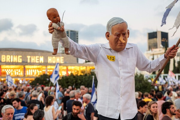 이스라엘 텔아비브 하비마 광장에서 하마스가 억류 중인 인질 석방을 요구하는 반정부 시위에서 한 참석자가 피노키오 코를 가진 이스라엘 총리 베냐민 네타냐후 가면을 쓰고 포즈를 취하고 있다. 2025. 07. 19 [AFP=연합뉴스]