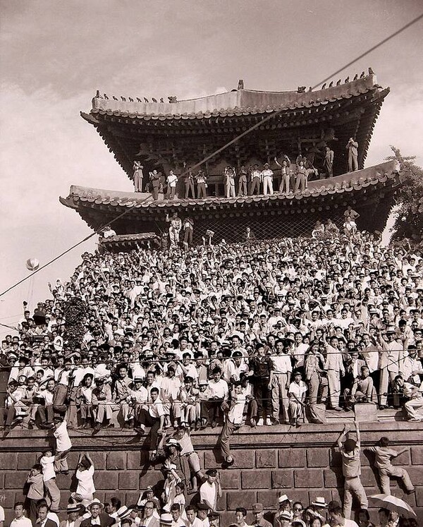 1960년 6월 20일 방한한 아이젠하워를 환영하기 위해 100만 명이 넘는 인파가 서울의 거리를 메웠다. 국보 1호 숭례문 지붕에까지 올라간 환영인파. 백악관 측은 한국 국민의 환영 열기가 상상을 초월했다며 감탄했다. ‘환영은 질서 있게’란 구호도 나왔다. (국사편찬위원회)