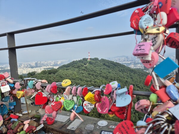 사랑의 자물쇠가 걸린 루프 테라스 난간 뒤로 미군 통신기지 캠프 모스가 보인다. (이희용 촬영)