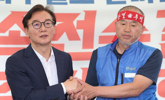 28일 정식 임명된 전재수 해양수산부 장관이 지난 17일 서울 여의도 국회 앞에서 해수부 부산 이전 반대 단식 투쟁 중인 윤병철 공무원노조 해수부지부 위원장과 만나 대화하며 손을 잡고 있다. 윤 위원장은 이날 전 장관 후보자(당시)과의 만난 자리에서 단식 투쟁 중단을 선언했다. 2025.7.17. 연합뉴스