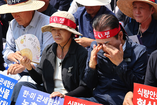 서울 한낮 기온이 36도까지 치솟으며 무더운 날씨를 보인 28일 서울 용산구 삼각지역 인근에서 열린 한미 상호관세 협상 농축산물 개방 반대 결의대회에서 한 참가자가 땀을 닦아내고 있다. 2025.7.28. 연합뉴스