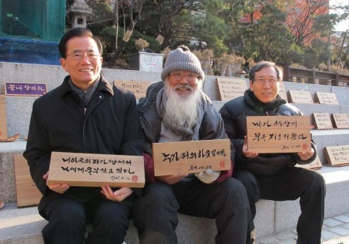 2010년 12월 16일, 명동 성당에서 문정현 신부를 찾은 두 신부가 각자 마음에 드는 서각 말씀을 들고 기념 사진을 찍었다. (왼쪽부터) 안충석 신부, 문 신부, 함세웅 신부. 사진 : 가톨릭뉴스 지금여기