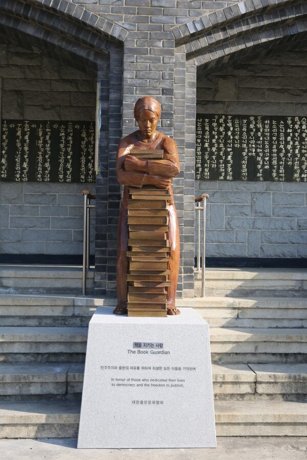 대한출판문화협회 건물 입구에 설치된 '책을 지키는 사람'(2024). 좌대에는 “민주주의와 출판의 자유를 위해 희생된 모든 이들을 기억하며”라고 새겨졌다. (사진출처: 대한출판문화협회 홈페이지)