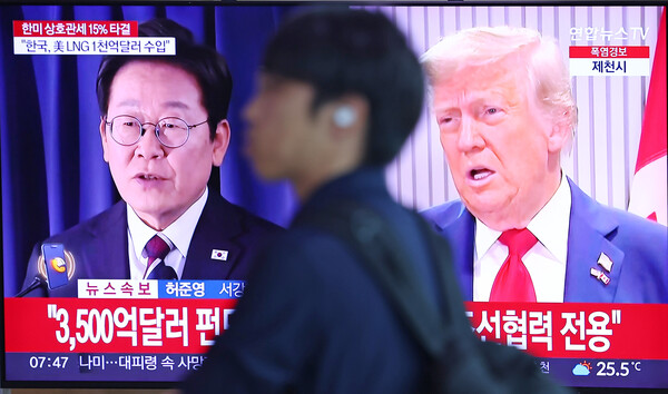 한국과 미국의 관세협상이 타결된 31일 서울역 대합실에서 한 시민이 관련 뉴스가 나오는 TV 앞을 지나고 있다. 2025.7.31 연합뉴스