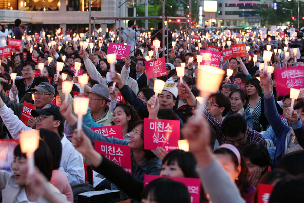서울 시청 앞 서울광장에서 열린 '광우병 위험 美쇠고기 전면수입 반대 촛불문화제'에서 시민들이 '미친소싫소, 협정무효' 등 문구와 촛불을 흔들고 있다. 연합뉴스