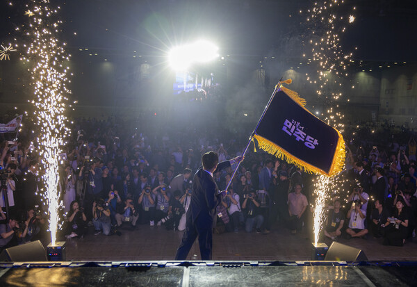 더불어민주당 정청래 신임 당대표가 2일 고양 킨텍스에서 열린 전국당원대회에서 김병기 당대표 직무대행 겸 원내대표로부터 받은 당기를 흔들고 있다. 2025.8.2 [공동취재] 연합뉴스