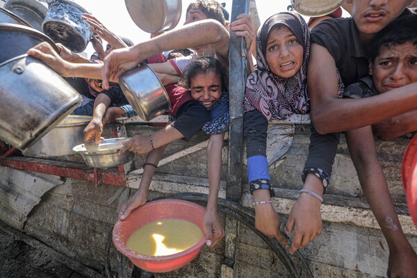아이들을 포함한 팔레스타인 난민들이 4일 가자시티의 자선 기관으로부터 식량을 받기 위해 그릇을 들고 있다. 2025. 08. 04 [EPA=연합뉴스]