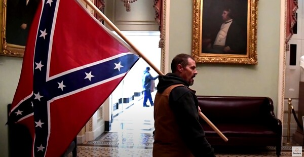 2021년 1월 미국 국회의사당 점거 사건 당시 한 폭도가 남북 전쟁 당시 사용했던 남부의 깃발을 들고 폭동을 벌이고 있다. (Reuters YouTube 갈무리) 