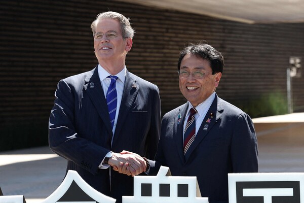 스콧 베센트 미국 재무부 장관이 지난 7월 19일 오사카에서 열린 미국 국경일 기념 행사에 참석하기 위해 오사카 엑스포의 미국관 앞에서 일본의 경제 활성화 장관이자 무역 관세 협상 수석 협상자인 료세이 아카자와(우)와 악수하고 있다. 2025.7.19. 지지통신 AFP 연합뉴스