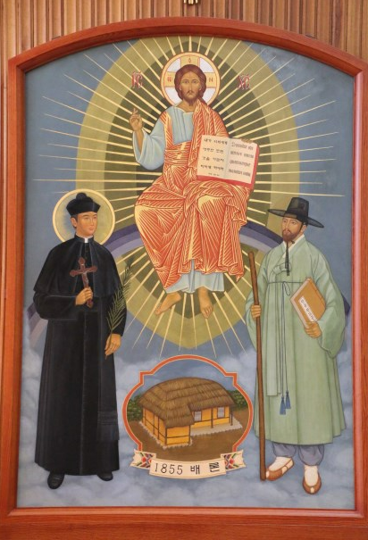 서울 종로구 혜화동 가톨릭대 신학대 성당에 설치된 개교 160주년 기념 성화 ‘파견하시는 예수님’. 장긍선 신부의 그림으로 가운데 무지개 위에 예수가 앉아 있고 좌우에 김대건·최양업 신부가 서 있다. 김대건은 십자가와 순교자 상징인 종려나무 가지, 최양업은 선교를 뜻하는 지팡이와 기도서인 천주성교공과를 들고 있다. 아래 초가집은 1855년 문을 연 성요셉신학당이다.